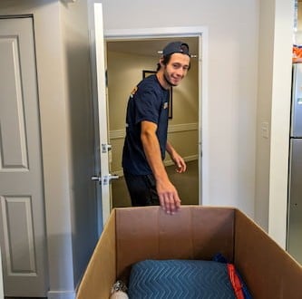 Crew navigating large items through a residential hallway